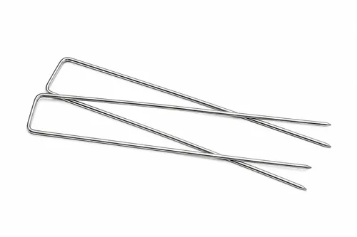 Twee U-vormige metalen kunstgrasankers met puntige uiteinden