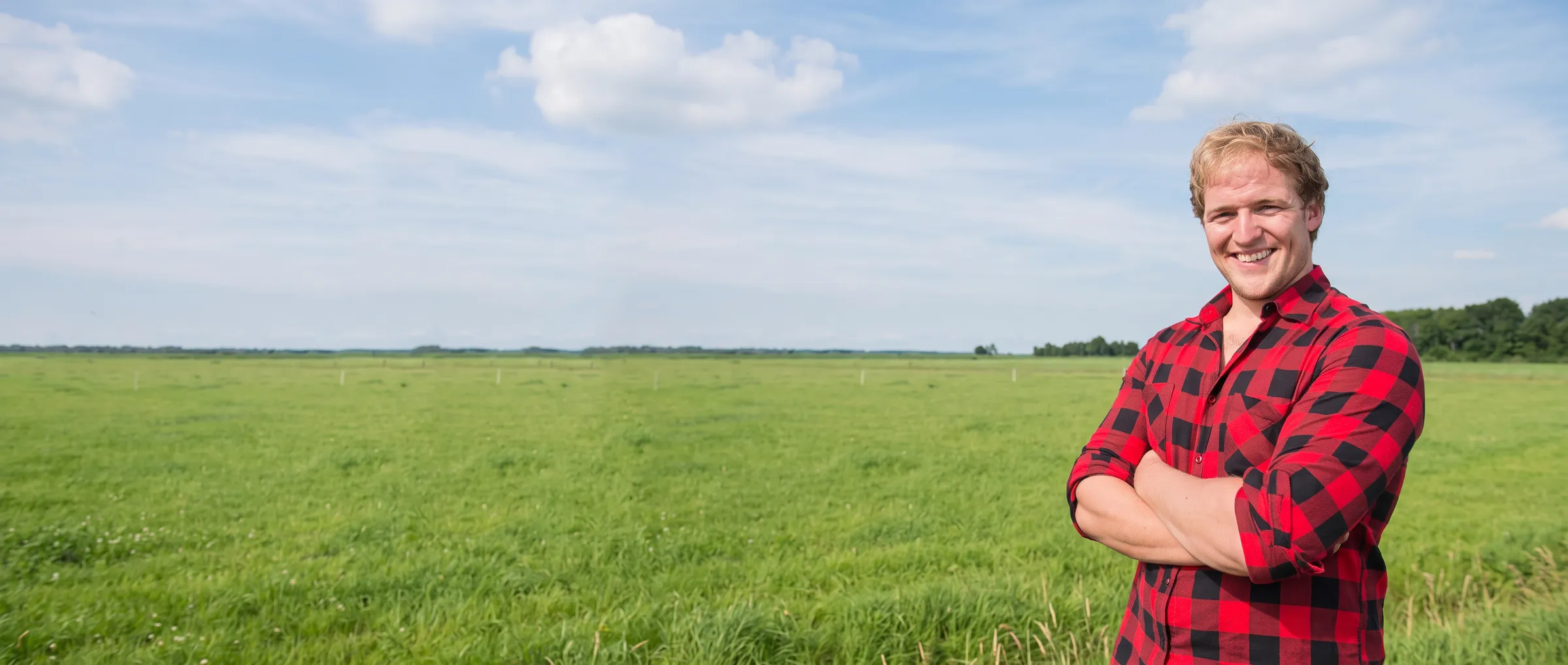 Medewerker van Kunstgrasboer in geruite blouse in een Hollands weiland